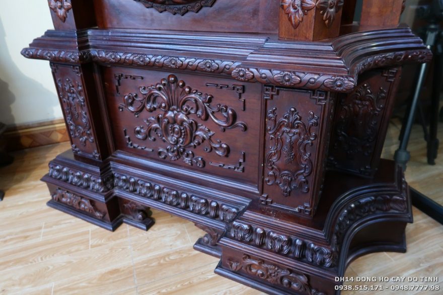 DH14: Đồng hồ cây máy tạ gỗ gụ dát vàng Sự kết tinh độc đáo, kỳ thú của hoa văn được thể hiện rất mượt trên phần đế vững trãi của chiếc đồng hồ cây (Ảnh: Dotinh.com)