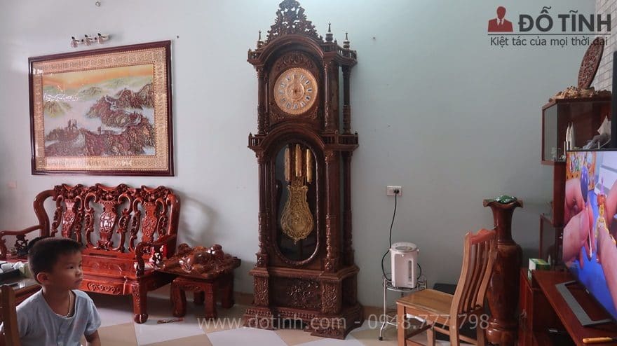 Chiếc đồng hồ cây gỗ mun đuôi công đang phô diễn nét đẹp sang trọng, lộng lẫy cho căn phòng khách - Ảnh: Dotinh.com